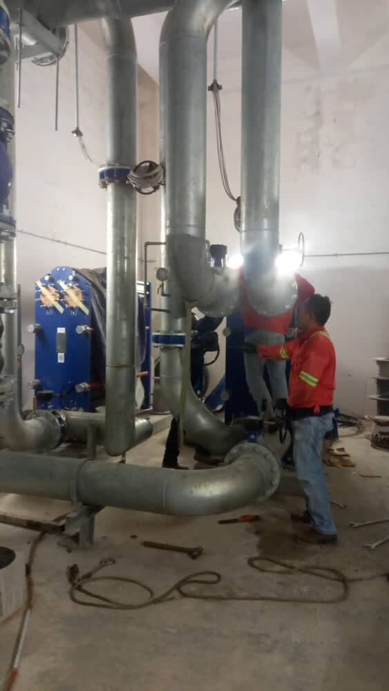 Chilled water plant pipework and heat exchanger with a technician on site