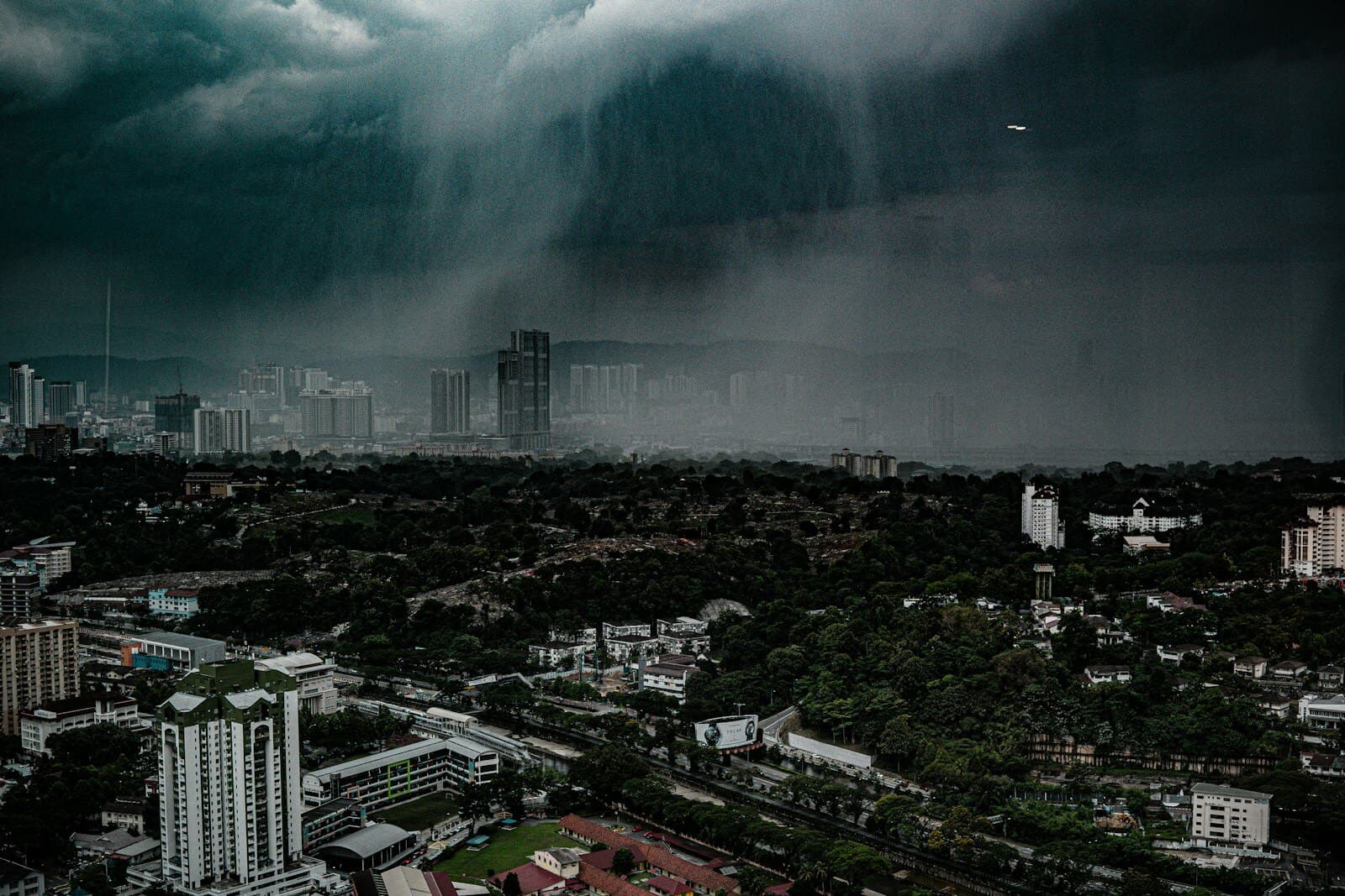A tropical rainstorm sweeping over a humid city skyline
