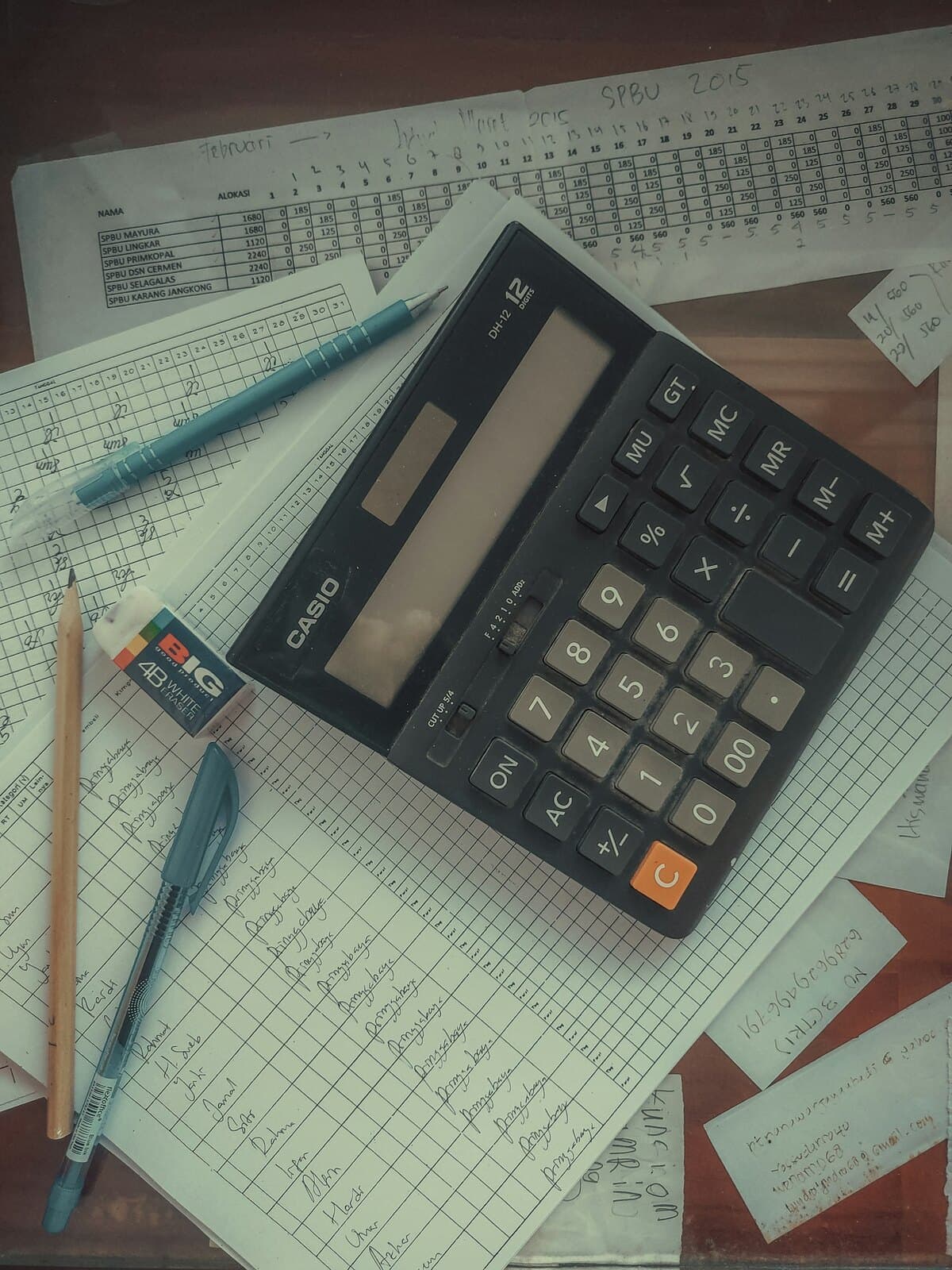 A calculator resting on columns of figures, working through a bill